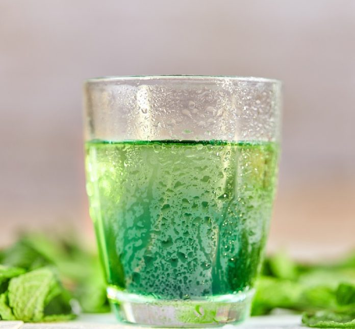 Mint chlorophyll drink in glass with water drops