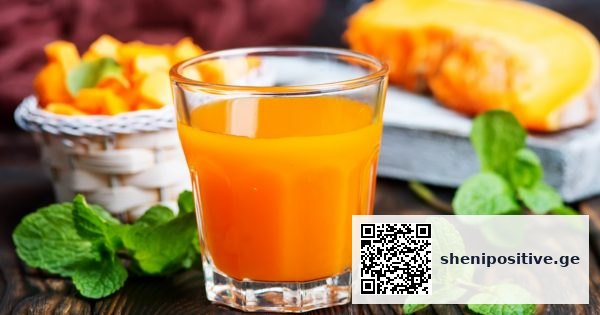 გოგრის წვენი გამჭვირვალე ჭიქაში ტაბუნება რბილი დილის შუქით